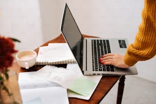 a woman using a laptop computer on a wooden desk