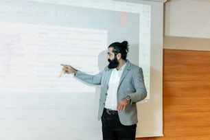 un uomo in piedi davanti a una lavagna bianca che fa una presentazione