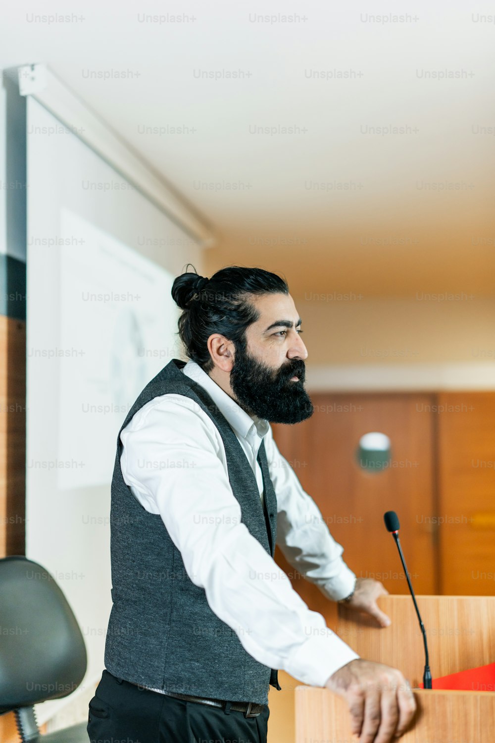 a man with a beard standing at a podium