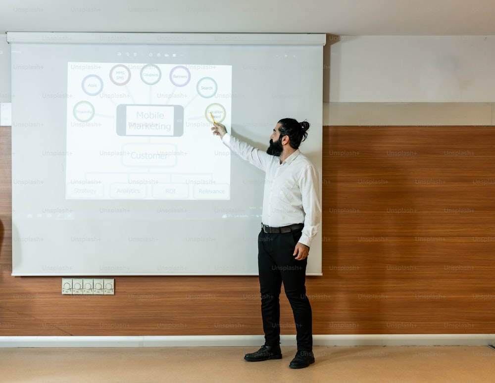 a man standing in front of a white board giving a presentation