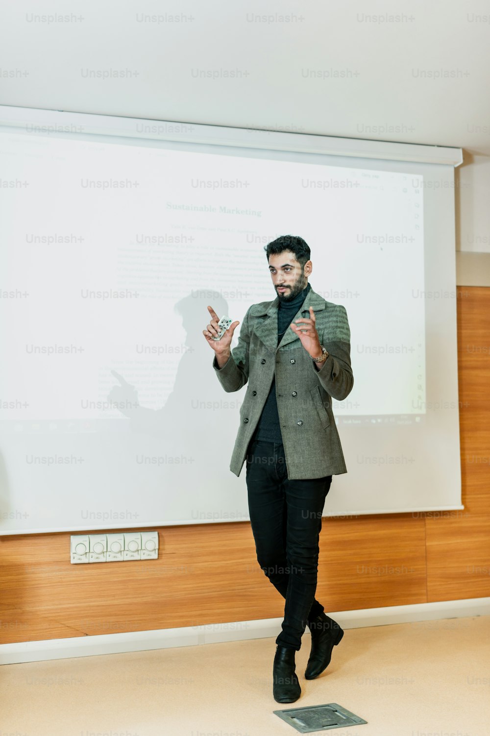 a man standing in front of a projector screen