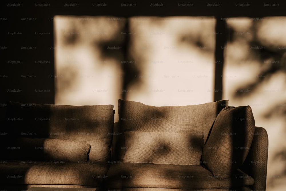窓の前に座る茶色のソファ
