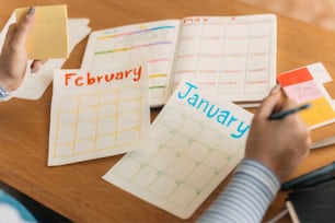Eine Person schreibt in einen Kalender auf einem Tisch
