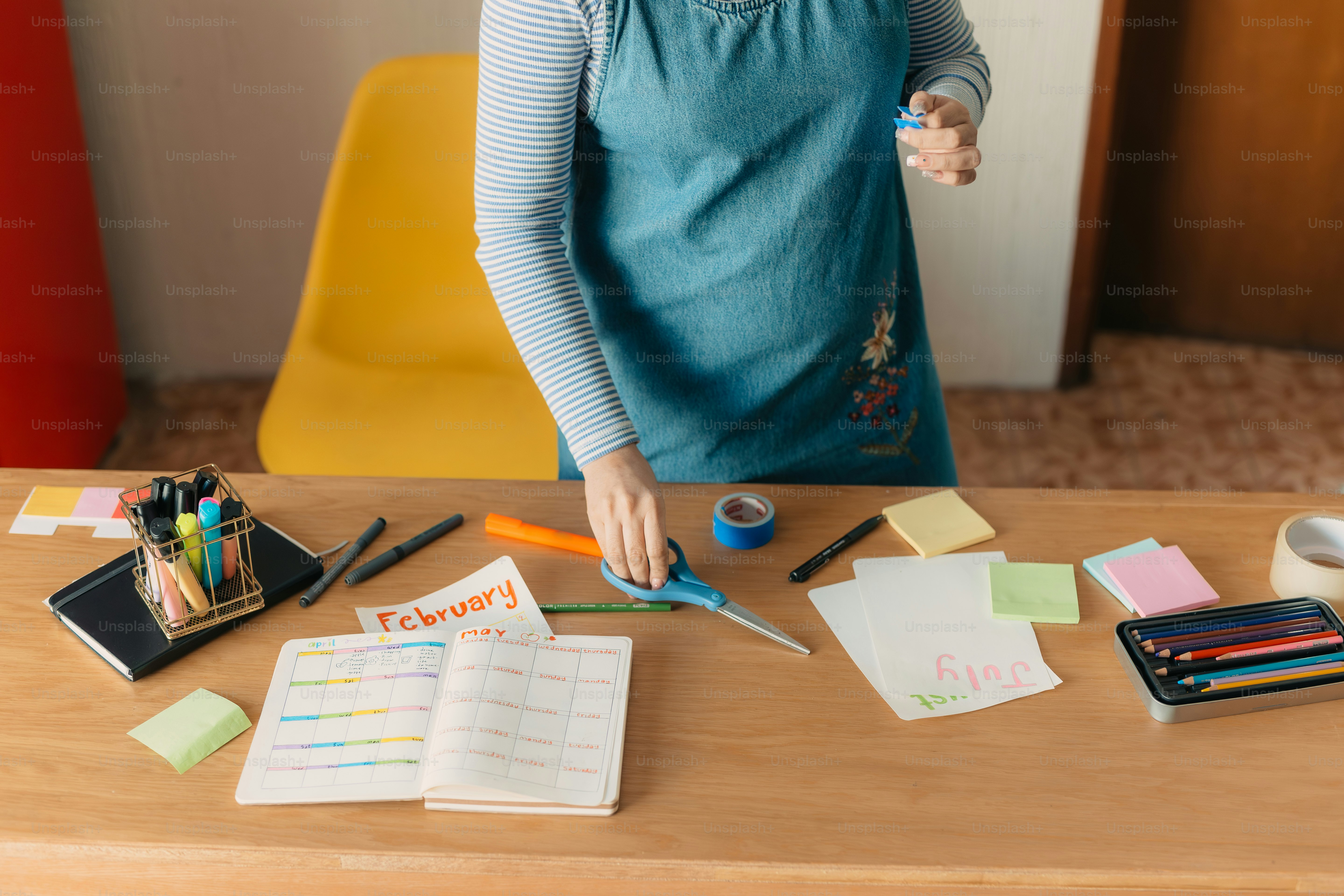 a young girl standing at a table with a pair of scissors