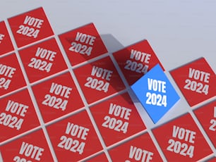um pedaço de papel azul sentado em cima de uma pilha de cartazes vermelhos de votação