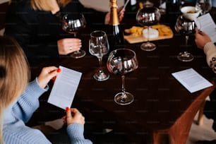 ワイングラスを片手にテーブルを囲む人々のグループ