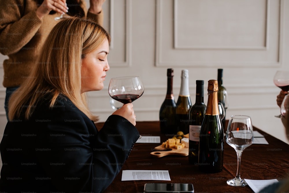 a woman sitting at a table with a glass of wine