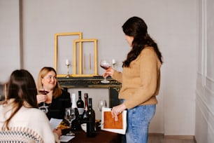 un gruppo di donne sedute intorno a un tavolo che bevono vino