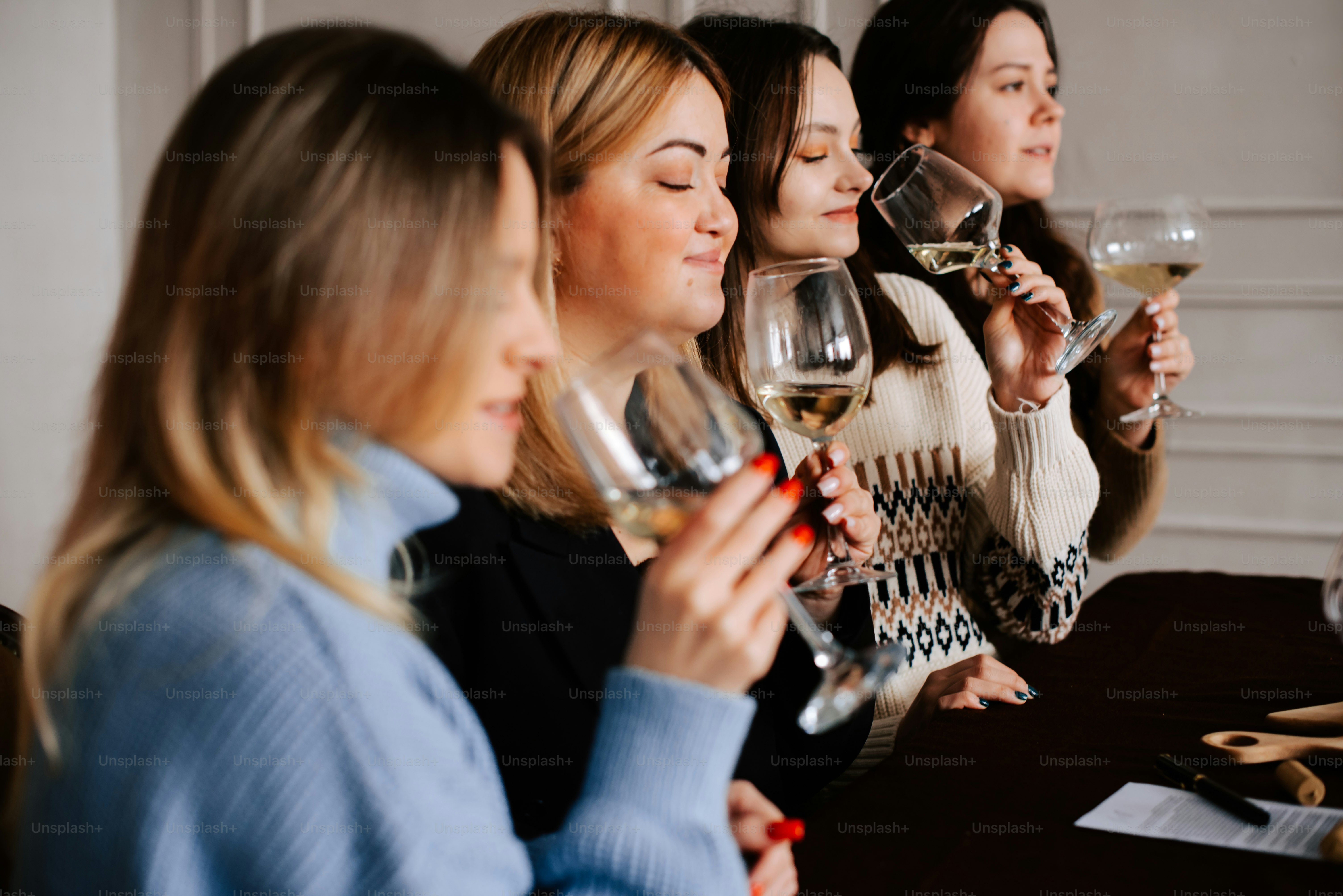 a group of women sitting at a table drinking wine