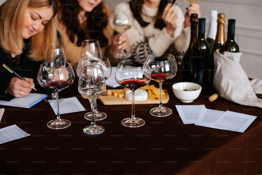 drei Frauen sitzen an einem Tisch mit Weingläsern