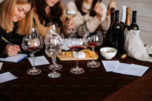 three women sitting at a table with wine glasses