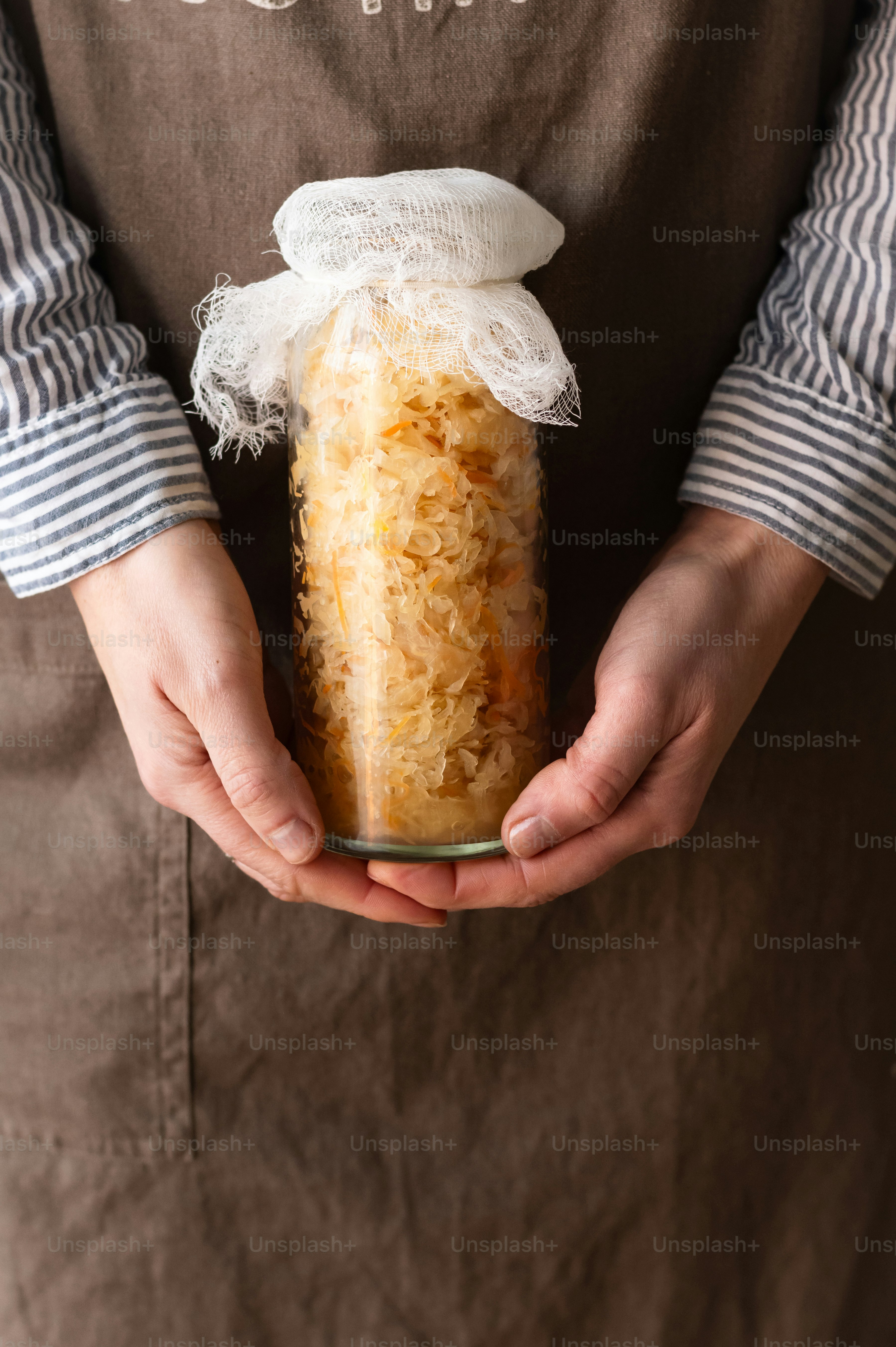 a person holding a jar of food in their hands