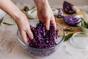 a person putting purple cabbage into a bowl