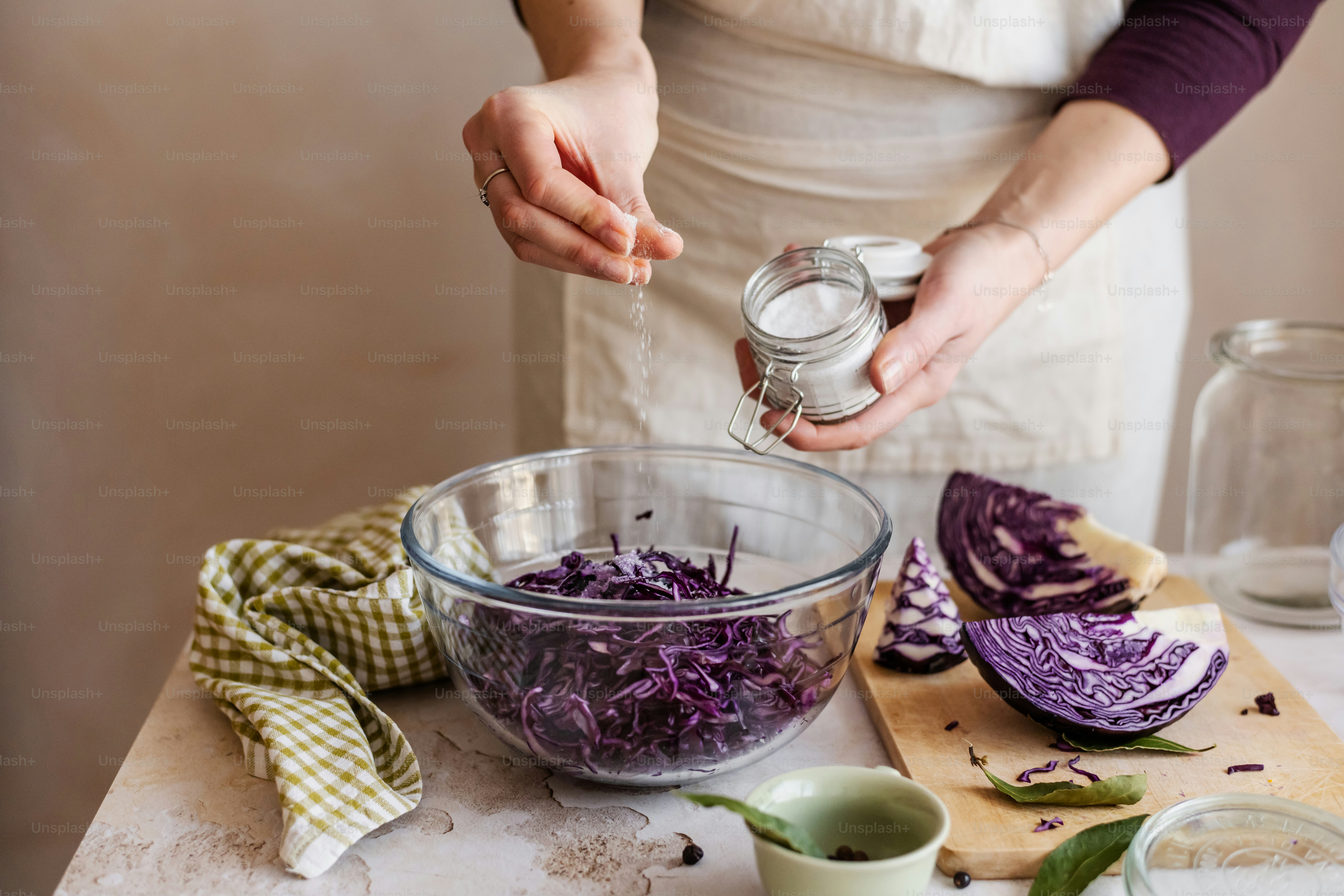 a woman in an apron is sprinkling something into a bowl
