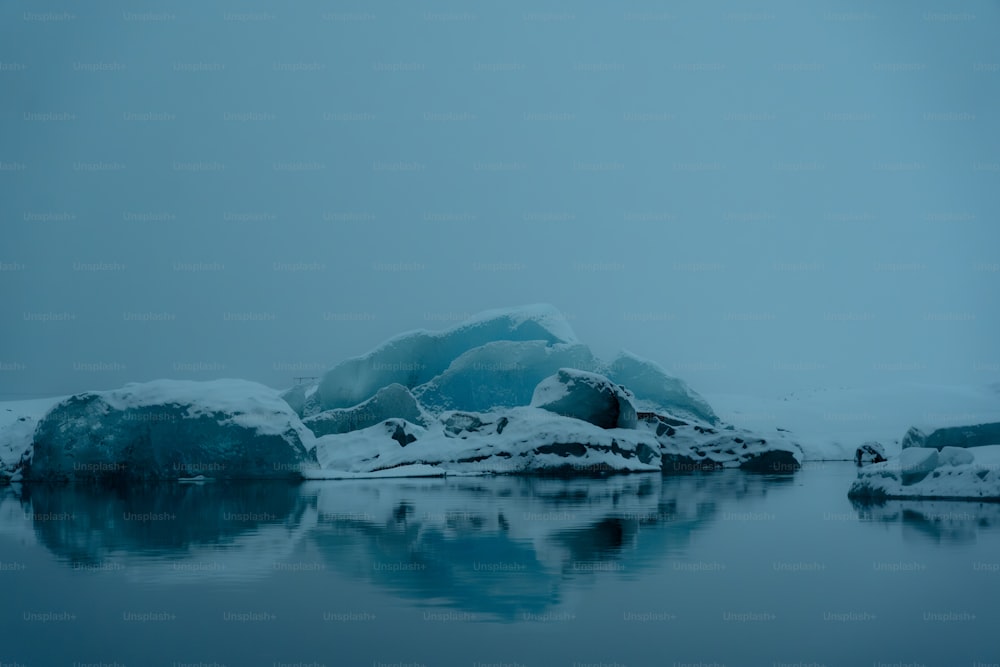 Un cuerpo de agua rodeado de rocas cubiertas de nieve