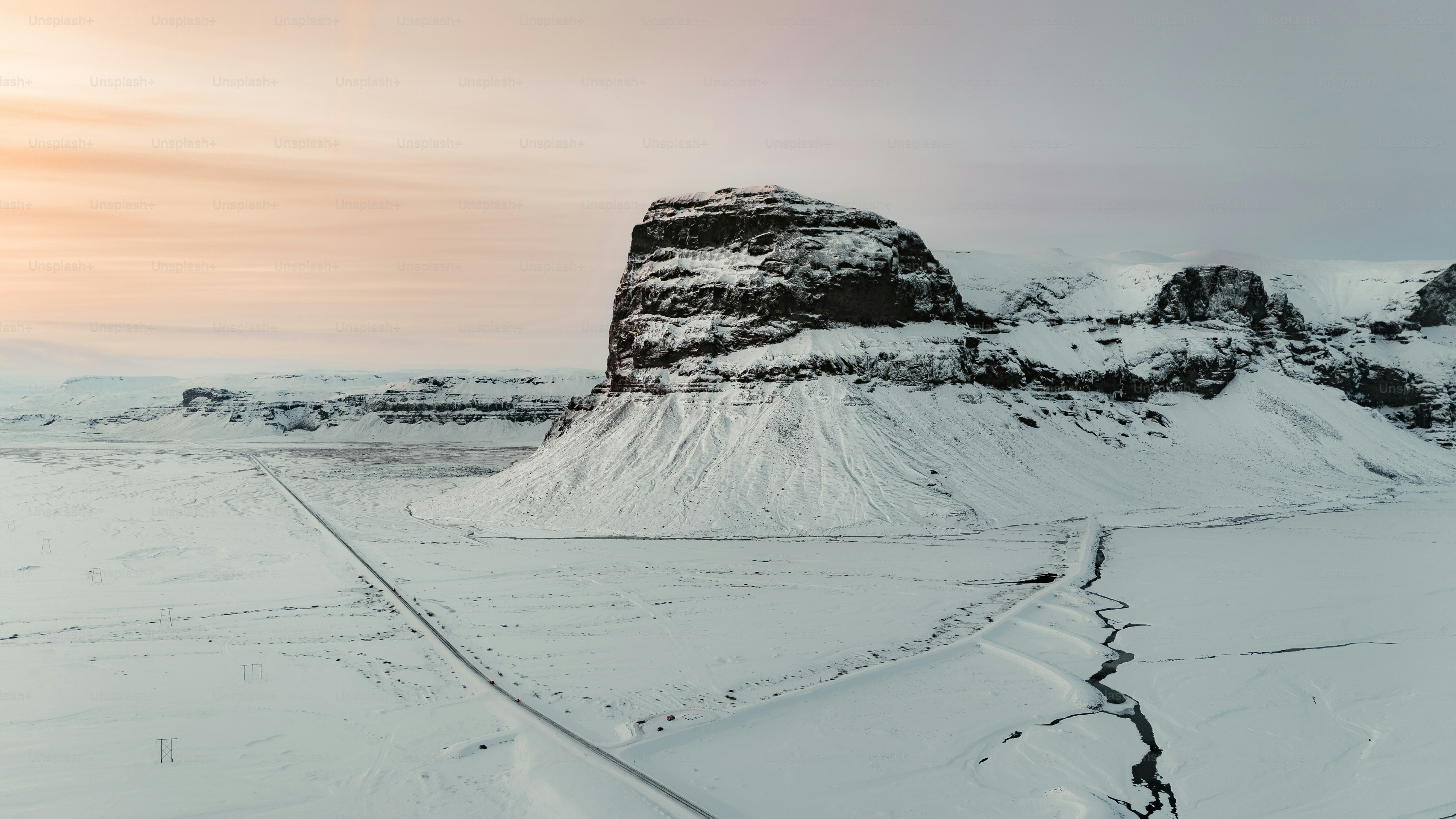 a snow covered mountain with a road going through it
