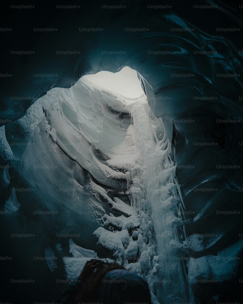 a man standing inside of a large ice cave