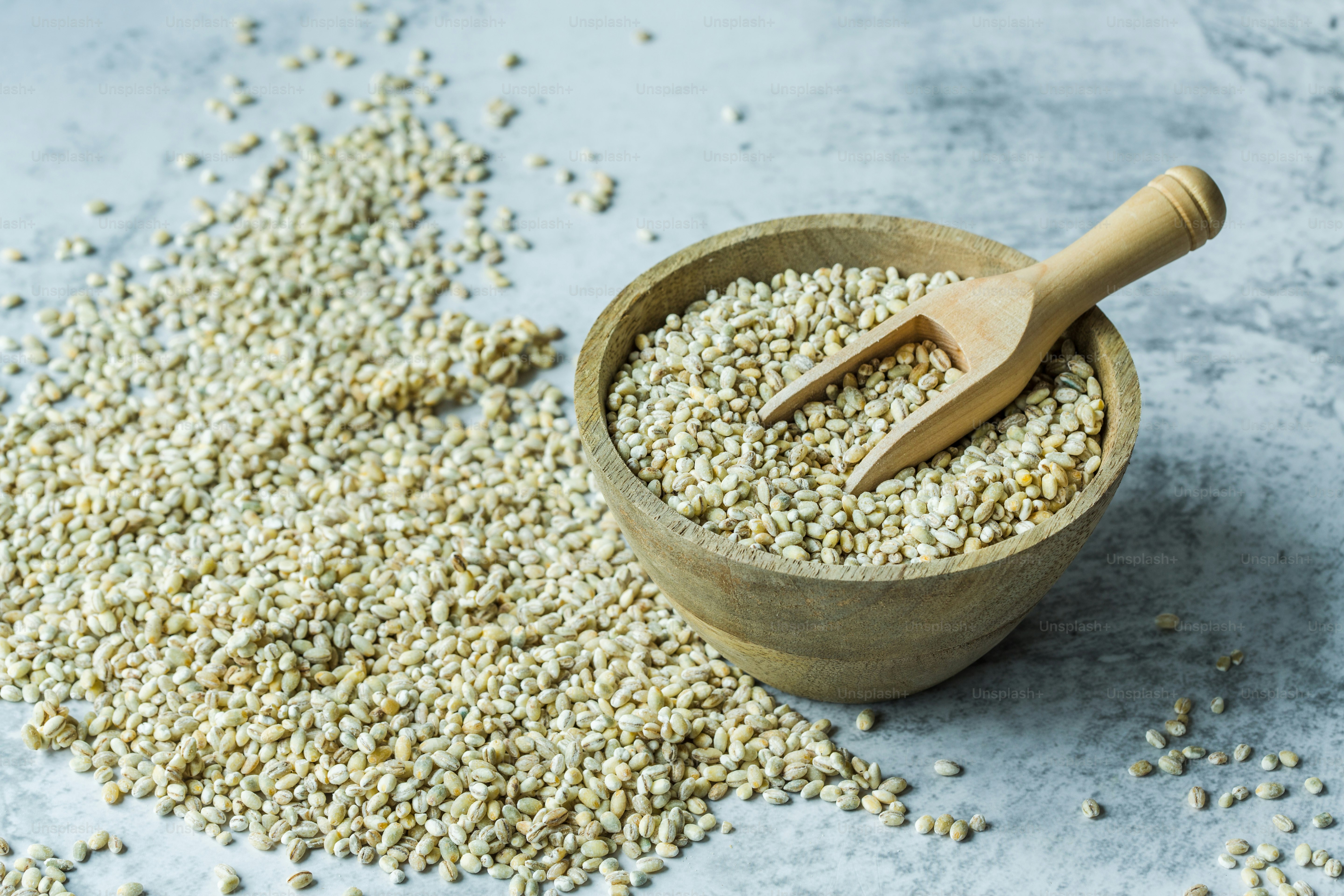 a wooden bowl filled with oats and a wooden spoon