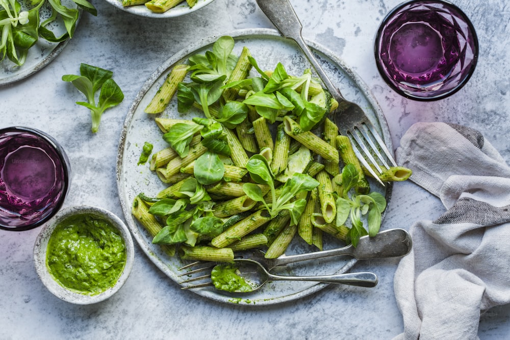 a plate of green pasta with pesto sauce