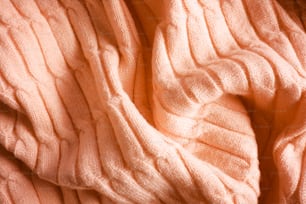 a close up of a sweater on a bed