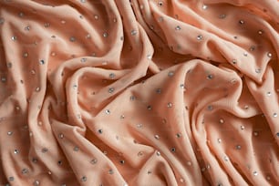 uma visão de perto de um tecido rosa com lantejoulas prateadas