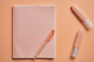 a pink notebook with a pen on top of it