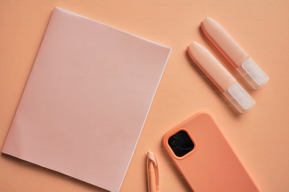 a notepad, pen, and a phone on a table