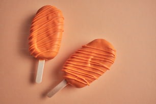a couple of orange lollipops sitting on top of a table