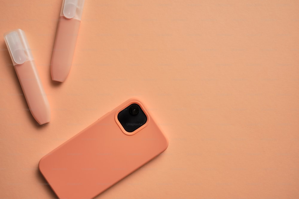 Une coque d’iPhone rose posée sur une surface rose