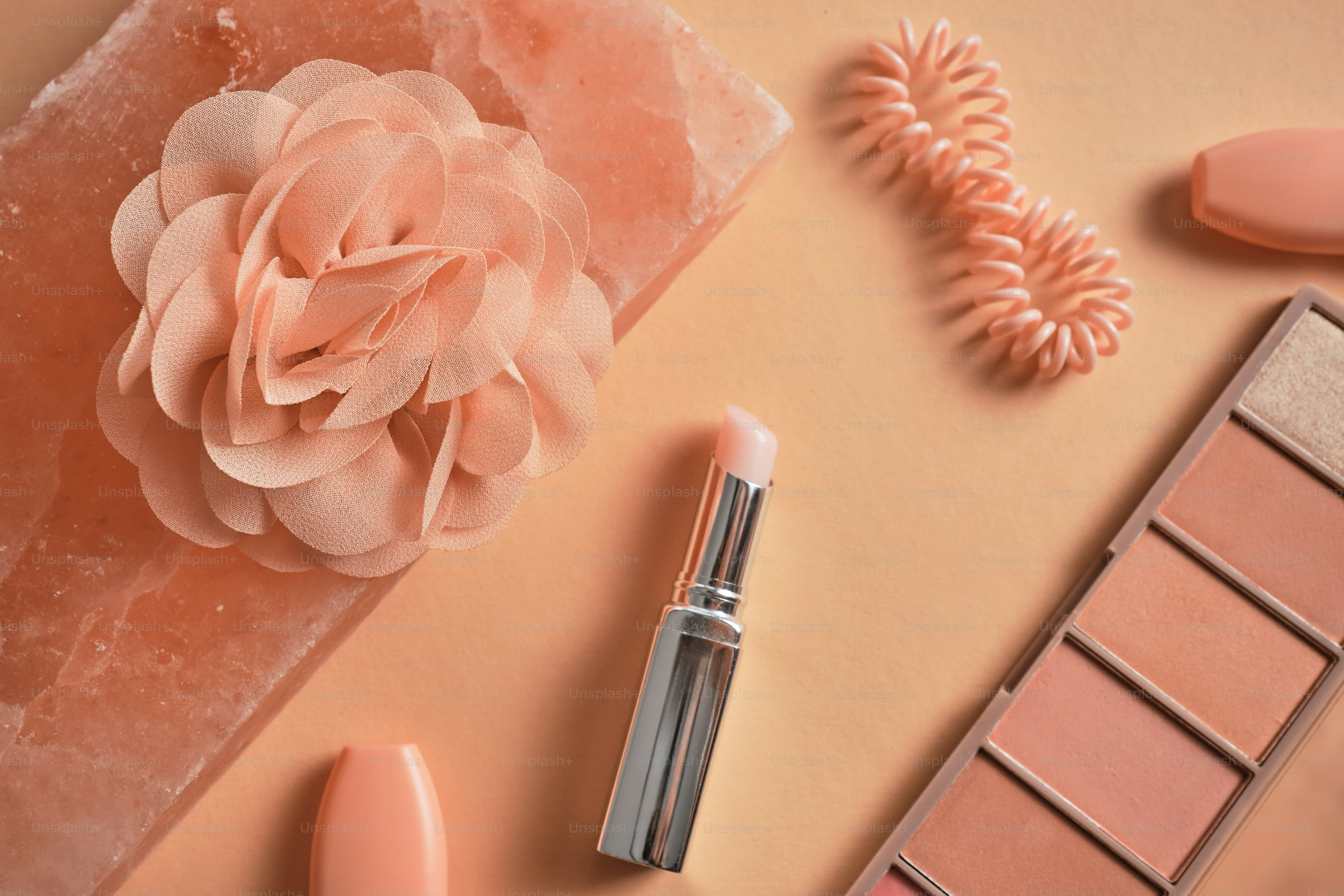 a close up of a lipstick and a flower on a table