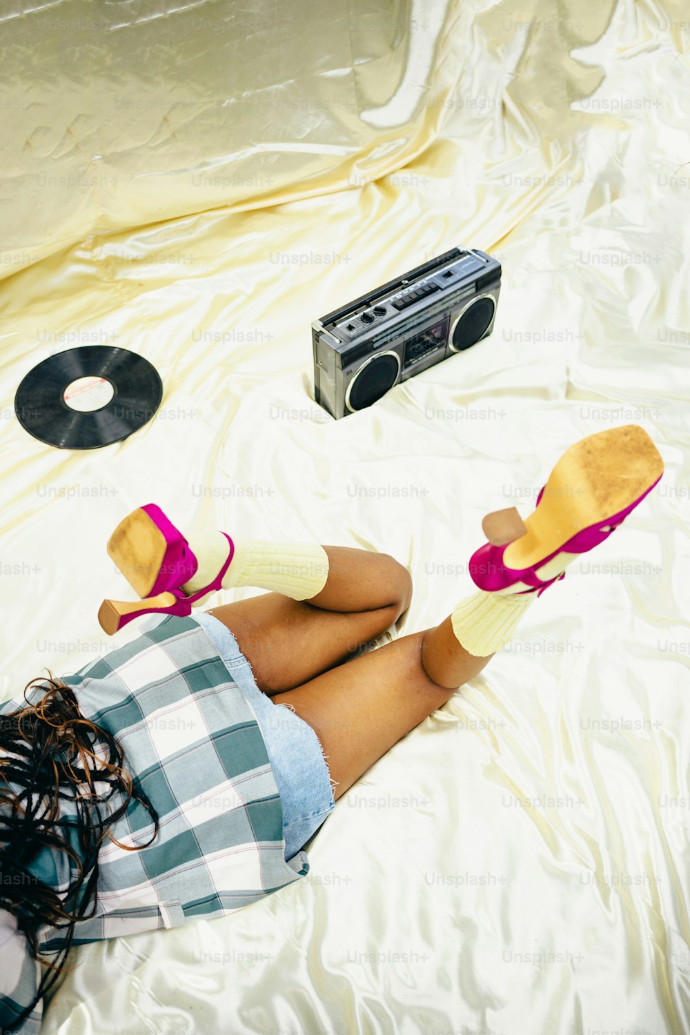 a person laying on a bed with a boombox and headphones