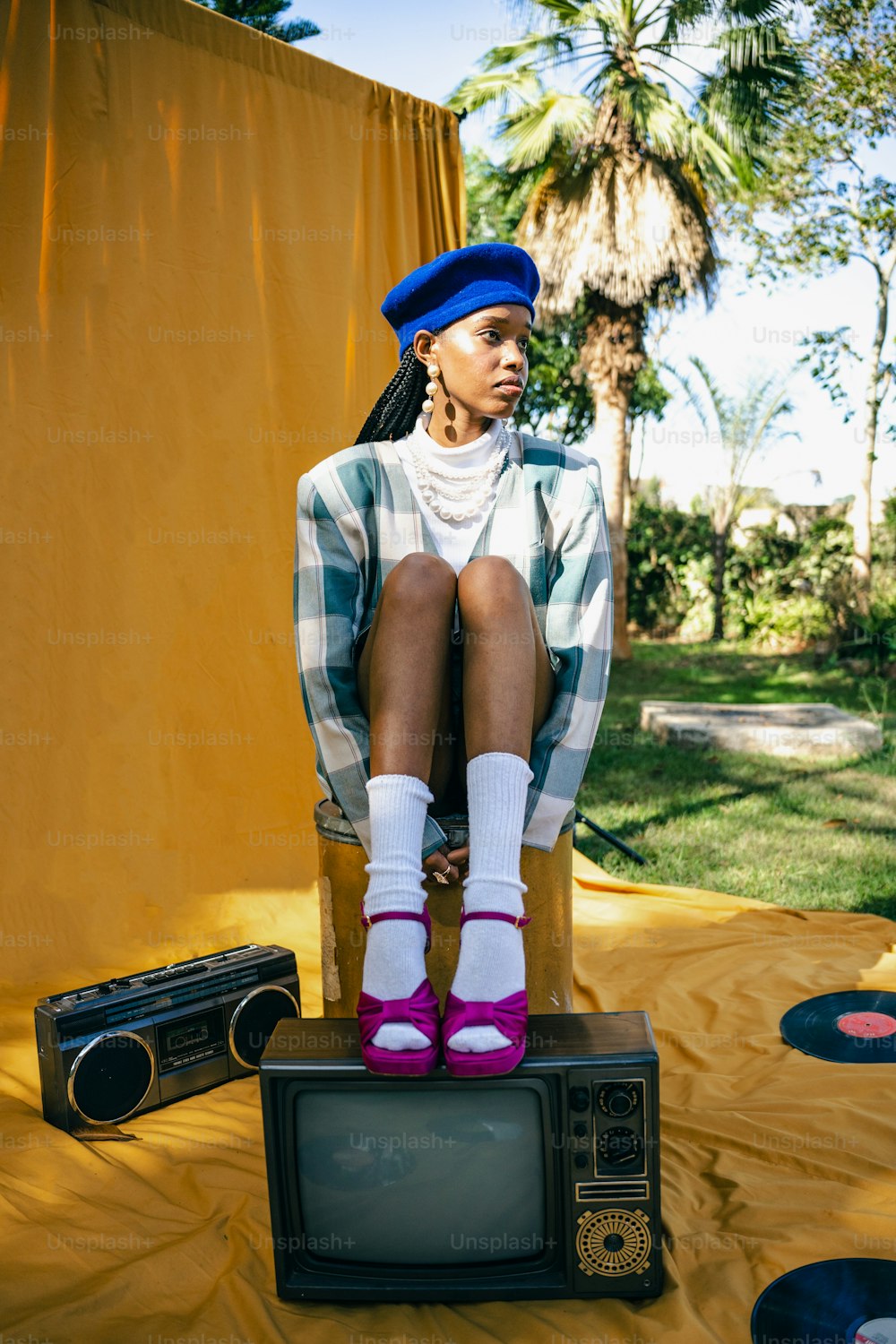 a woman sitting on top of a tv set