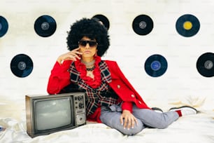 a woman sitting on a bed in front of a tv