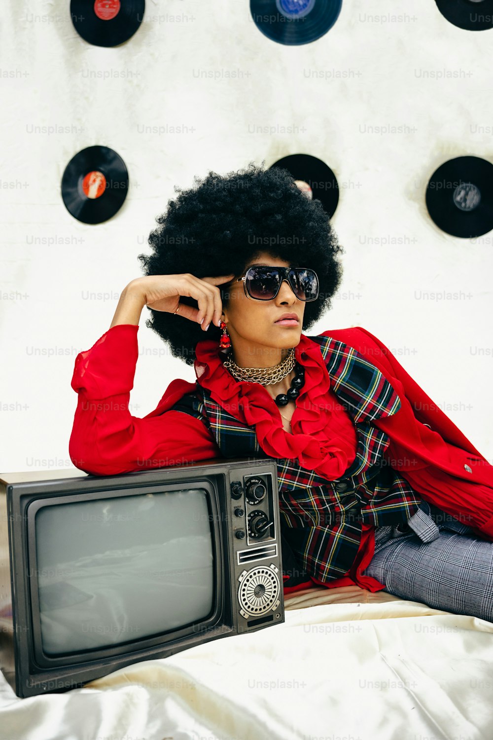 a woman sitting on a bed next to a tv