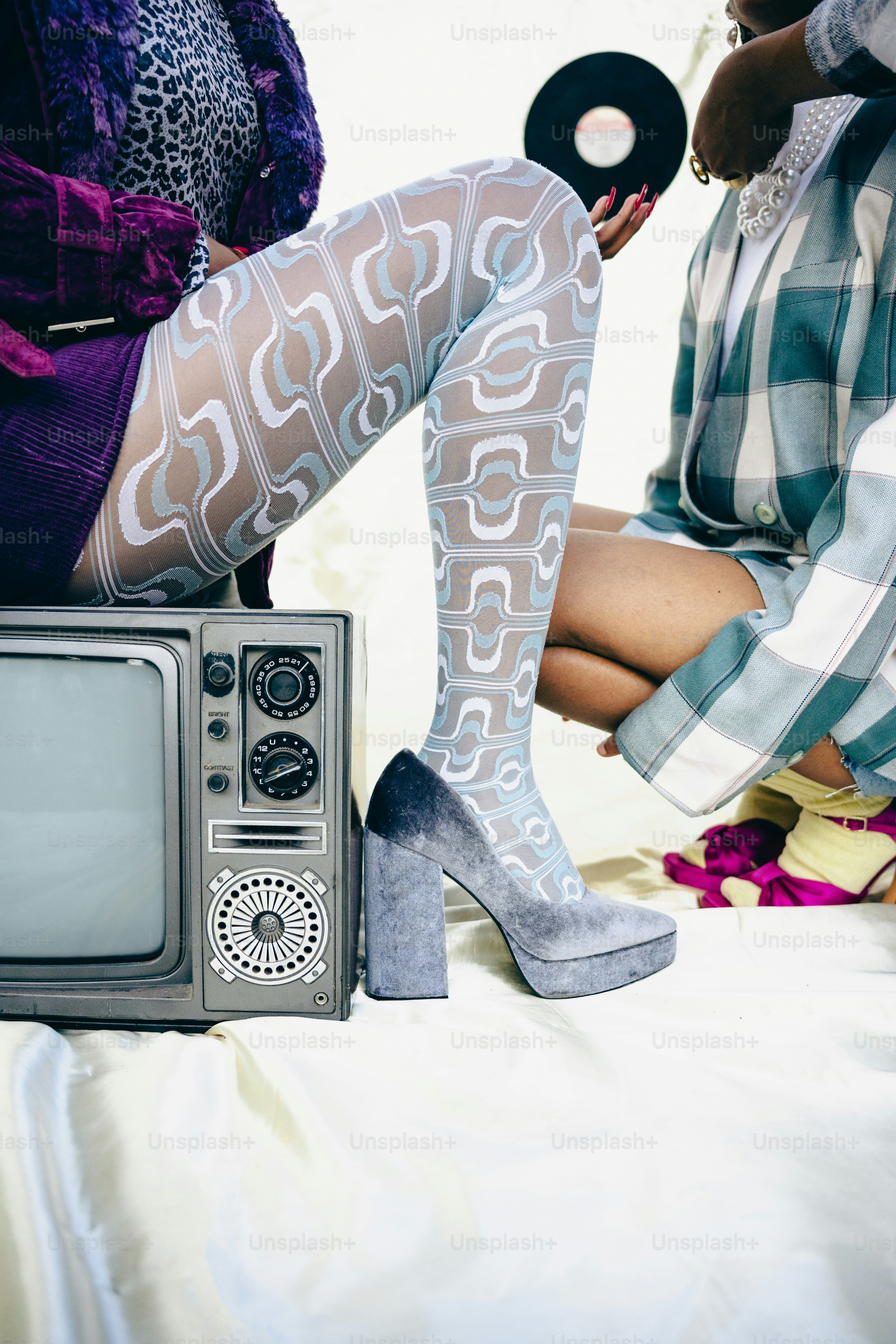 a woman sitting on top of a bed next to a tv