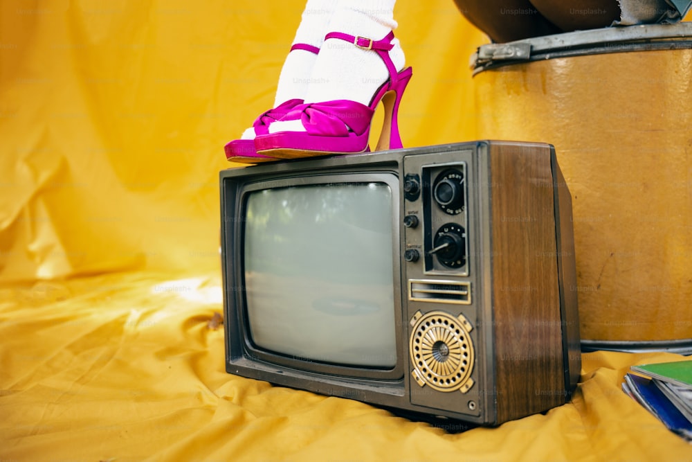 a small tv with a shoe on top of it