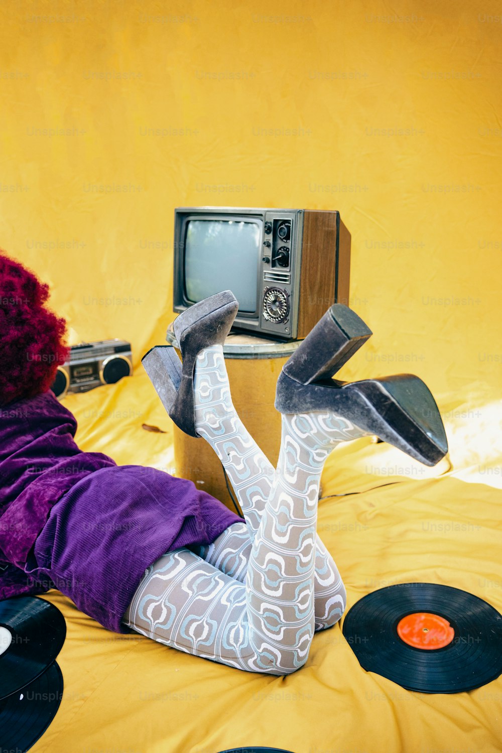 a woman laying on top of a bed next to a tv