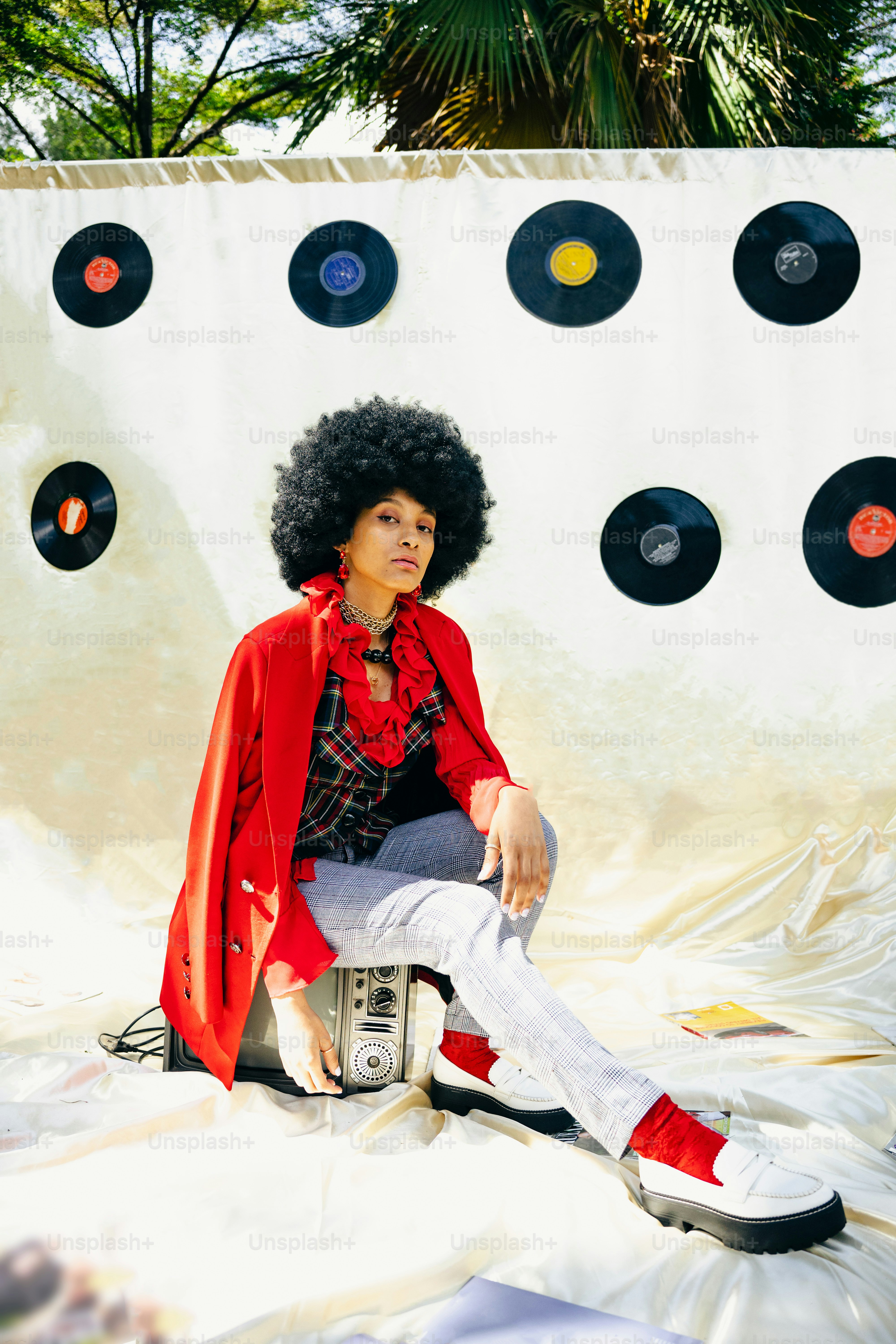 a woman sitting on top of a pile of records