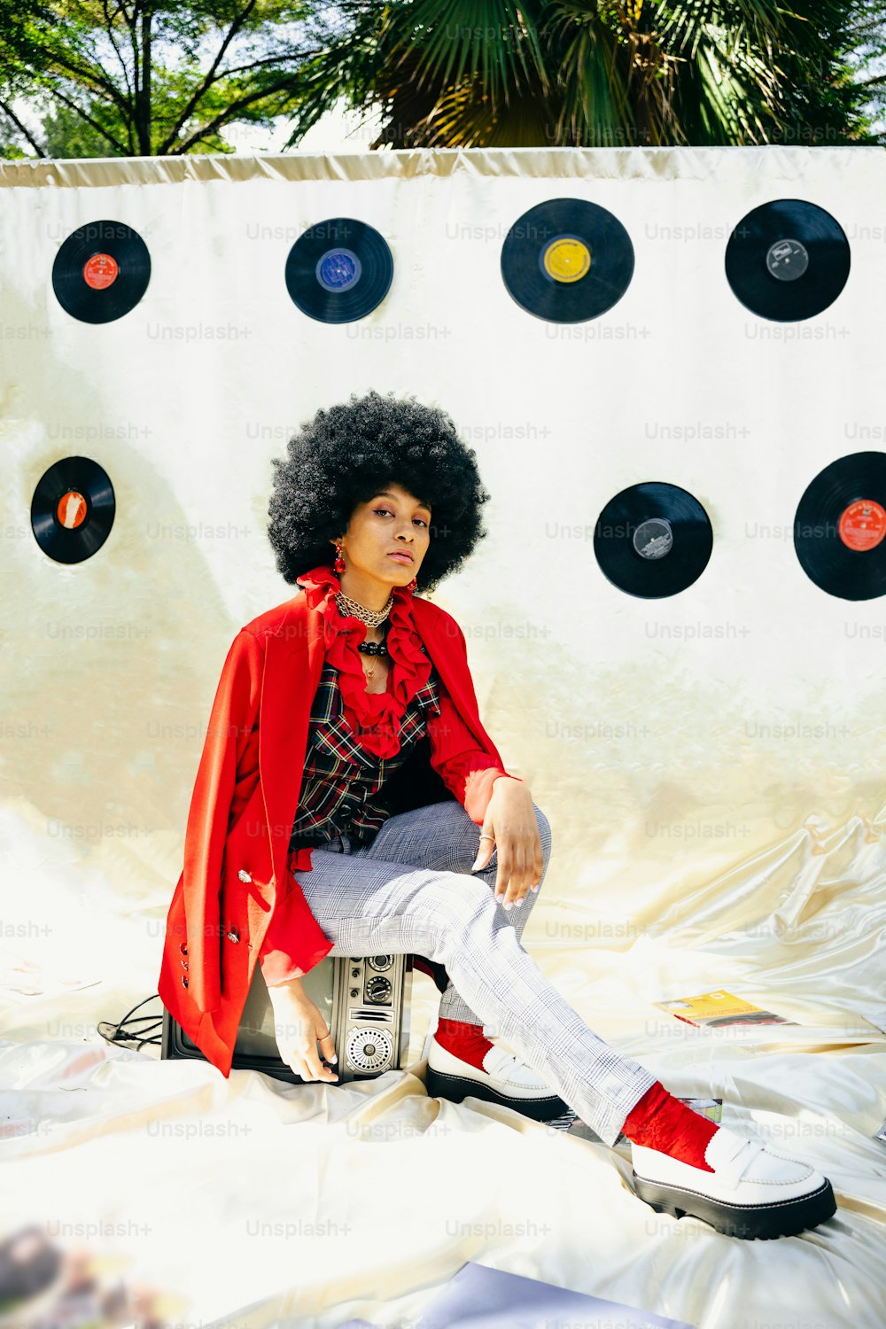 a woman sitting on top of a pile of records