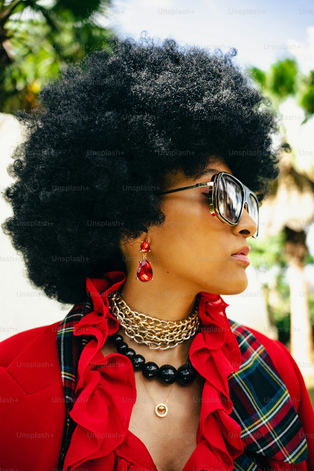 a woman with an afro wearing sunglasses and a red shirt
