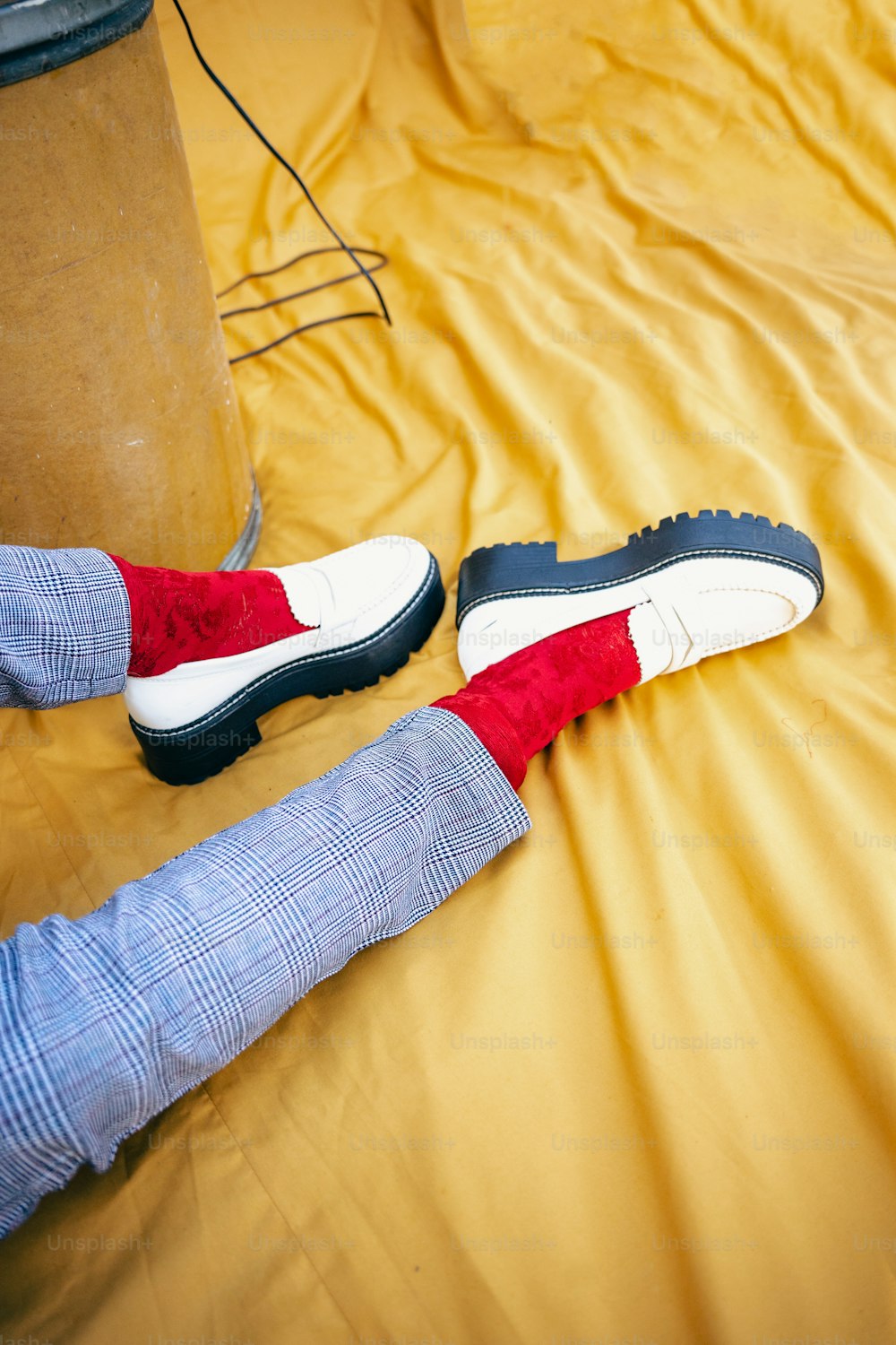 a person laying on a bed with red and white shoes