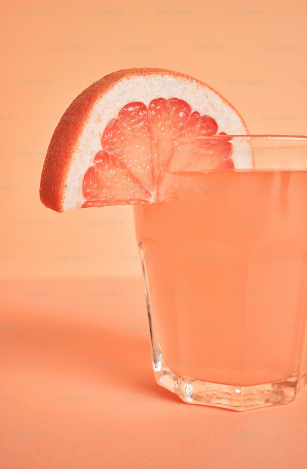 a grapefruit drink with a slice of grapefruit on the rim