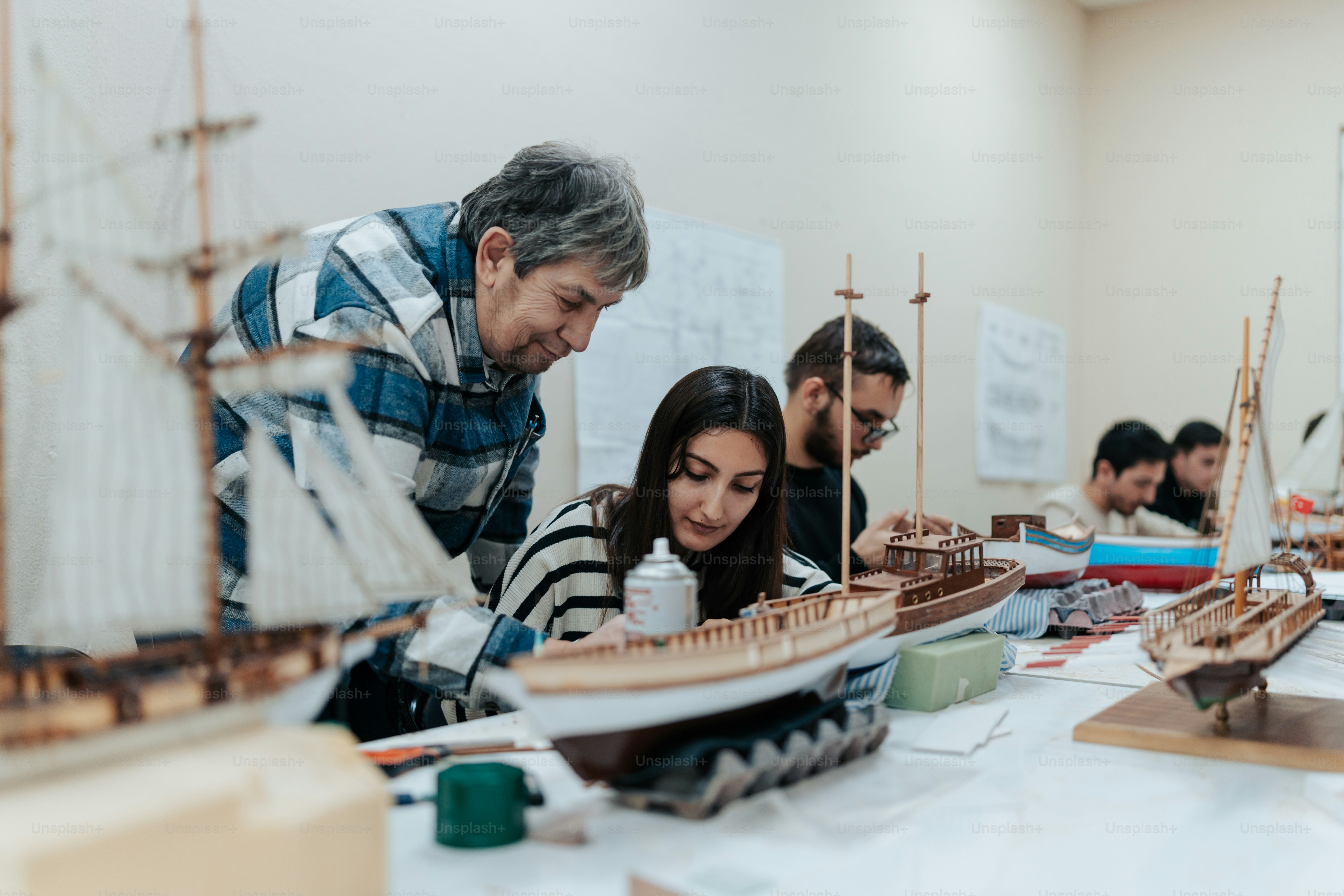 un groupe de personnes regardant une maquette d’un navire