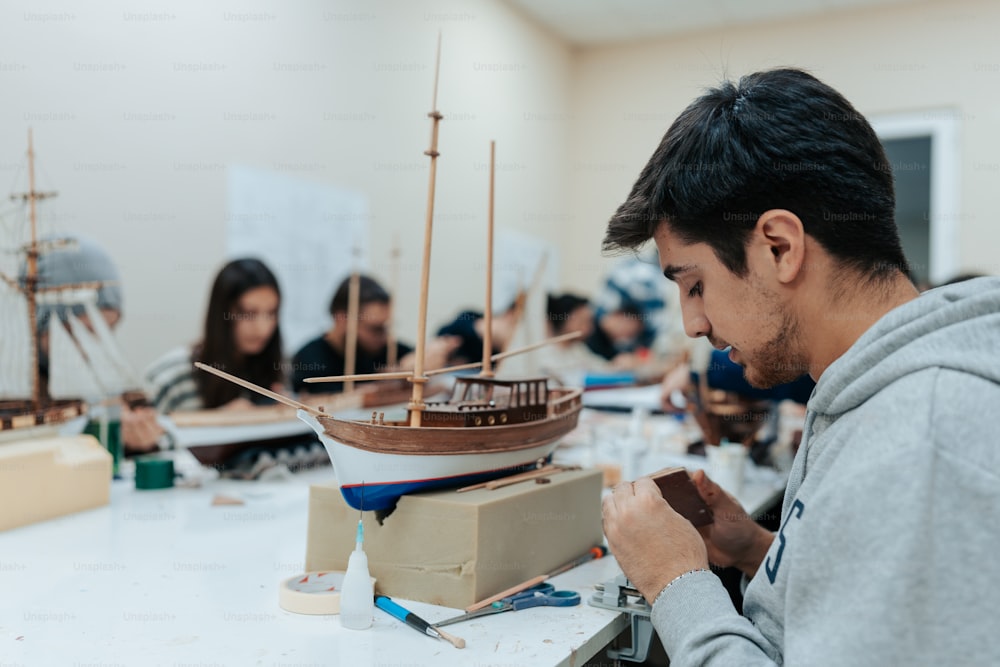 a man working on a model of a boat