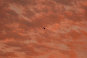 ein Flugzeug, das bei Sonnenuntergang durch einen bewölkten Himmel fliegt