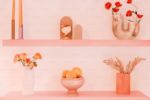 a pink shelf with vases and flowers on it
