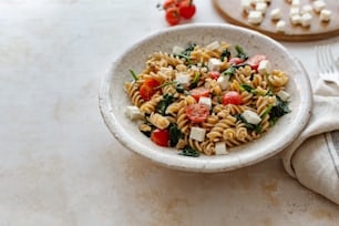 a white bowl filled with pasta and vegetables