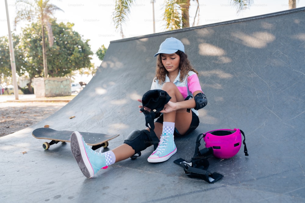 Eine Frau sitzt auf einem Skateboard neben einem Helm