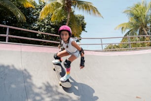 a young girl riding a skateboard down a ramp