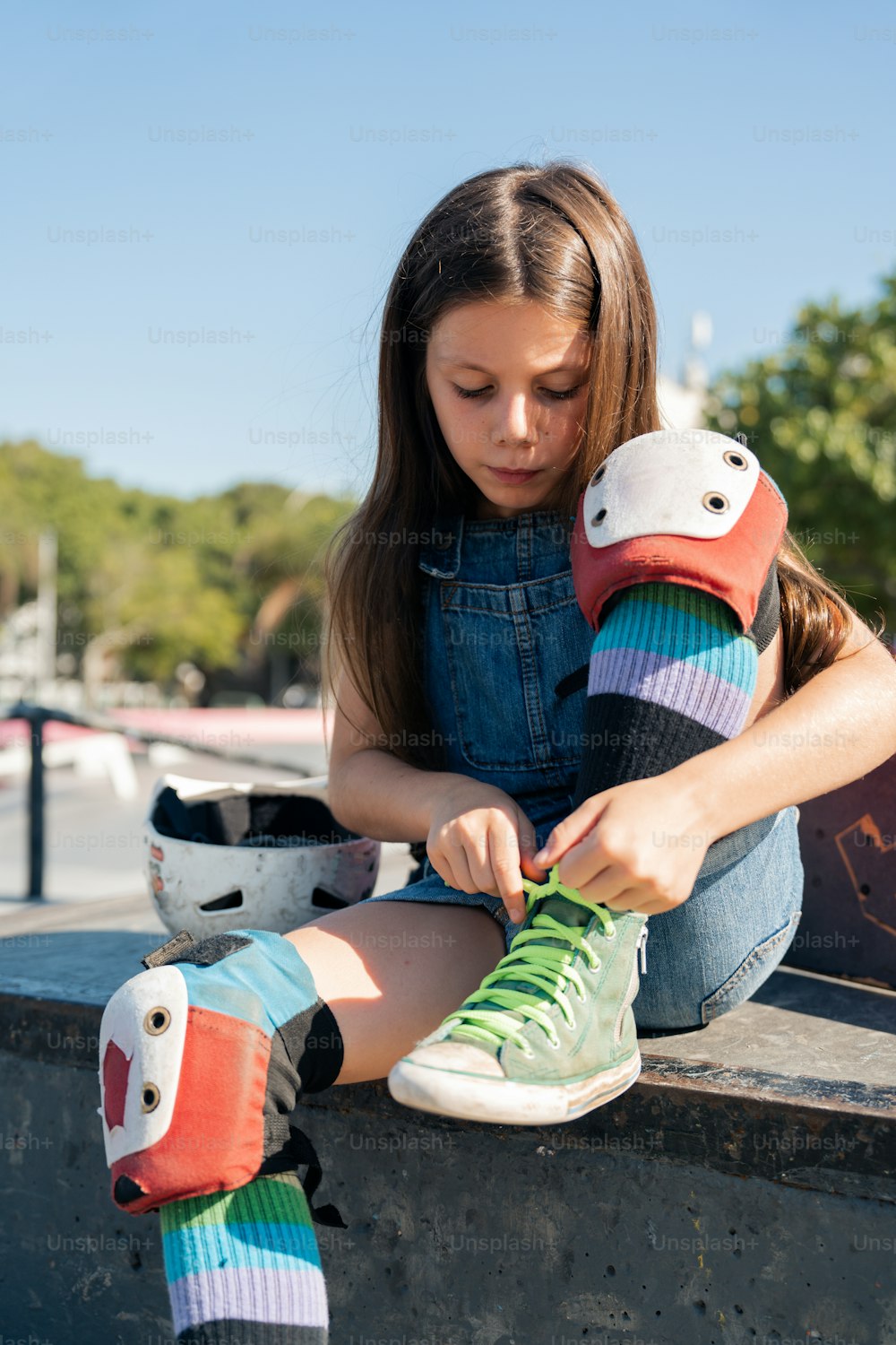 a young girl sitting on a skateboard holding a pair of shoes